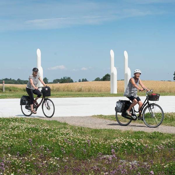 Cyklister på cykeltur ved Jelling-monumenterne