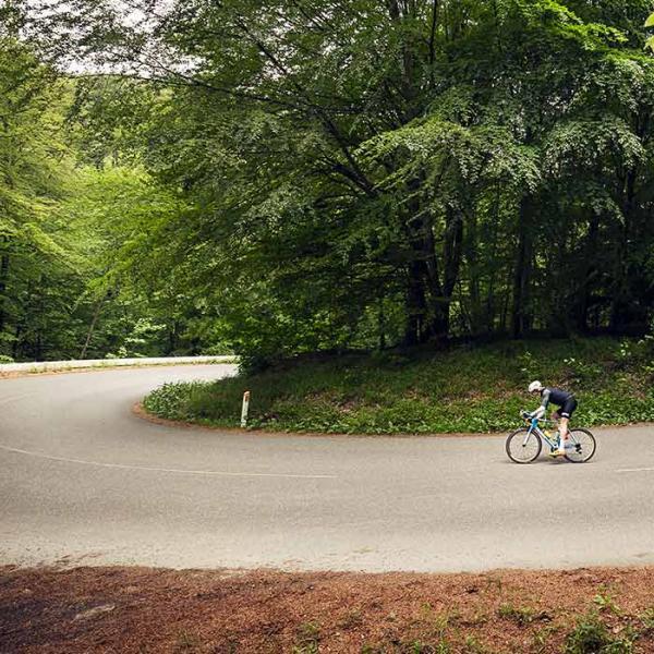 Cykelrytter cykler i hårnålesvinget ved Munkebjerg