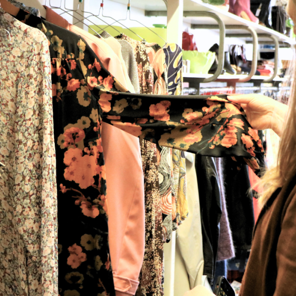 En person kigger på tøj i en genbrugsbutik i Give