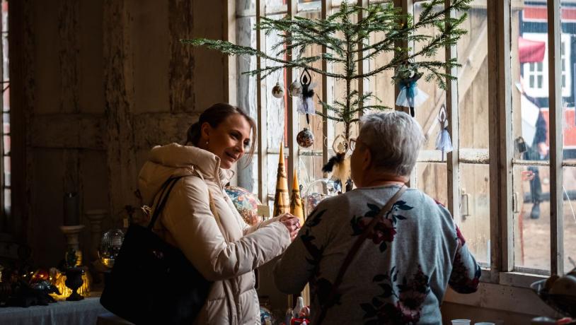 To personer kigger på boder til julemarkedet på Tirsbæk Gods