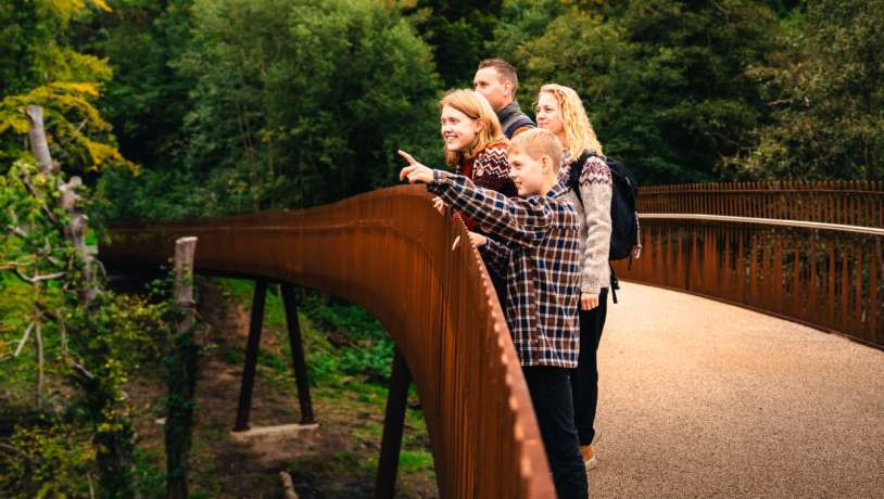 Familie på tur på stibroen over Grejsdalen 