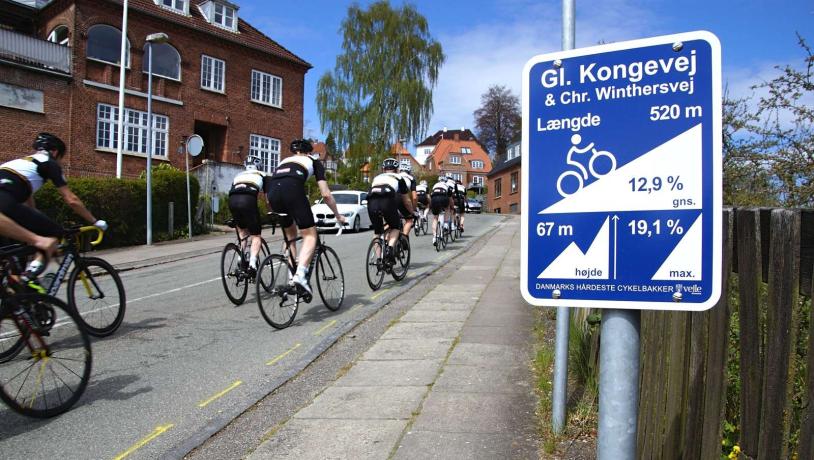 Bakkeskilt og cykelryttere på Gl. Kongevej i Vejle 