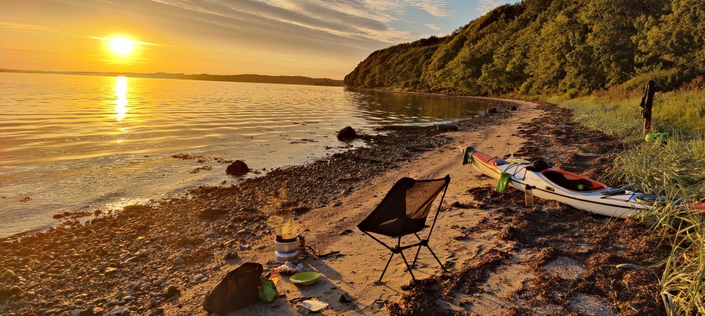 Kajak ved stranden med solopgang