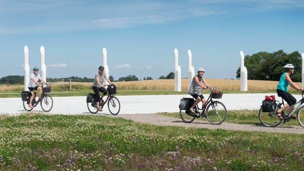 Cyklister på cykeltur ved Jelling-monumenterne