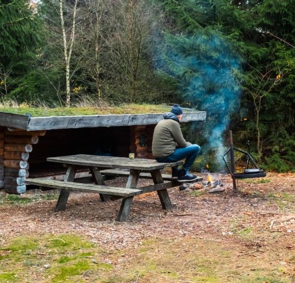 En person er på sheltertur i Frederikshåb Plantage og laver bål