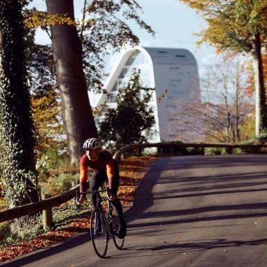 Cykelrytter på en efterårscykeltur i Nørreskoven i Vejle med Bølgen i baggrunden