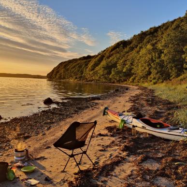 Kajak ved stranden med solopgang