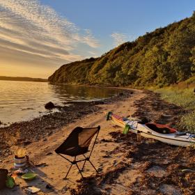 Kajak ved stranden med solopgang