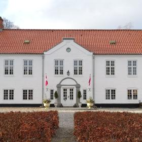 Hovedbygningen af Haughus Gods set ude fra gårdspladsen en forårs dag