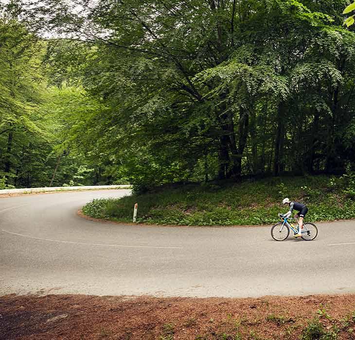 Cykelrytter cykler i hårnålesvinget ved Munkebjerg
